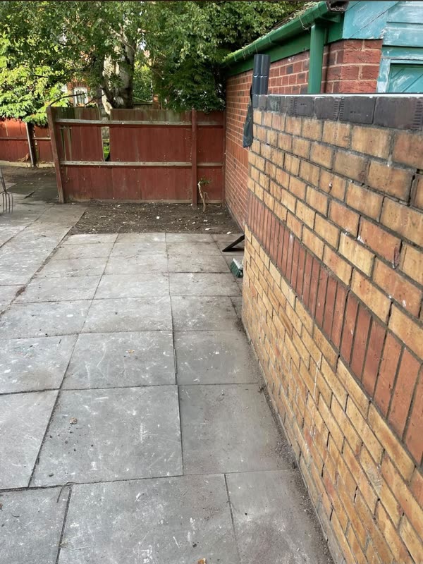 After: the same yard cleared, with a clean swept patio and tidy borders