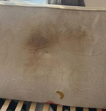 Before: white cot mattress with a large brown stain in the centre